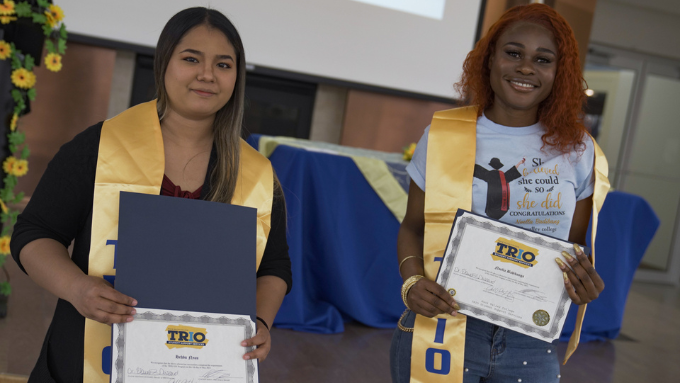 two students holding their certificates