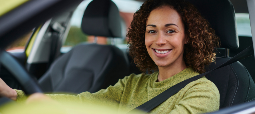 female in green sweater behind the wheel